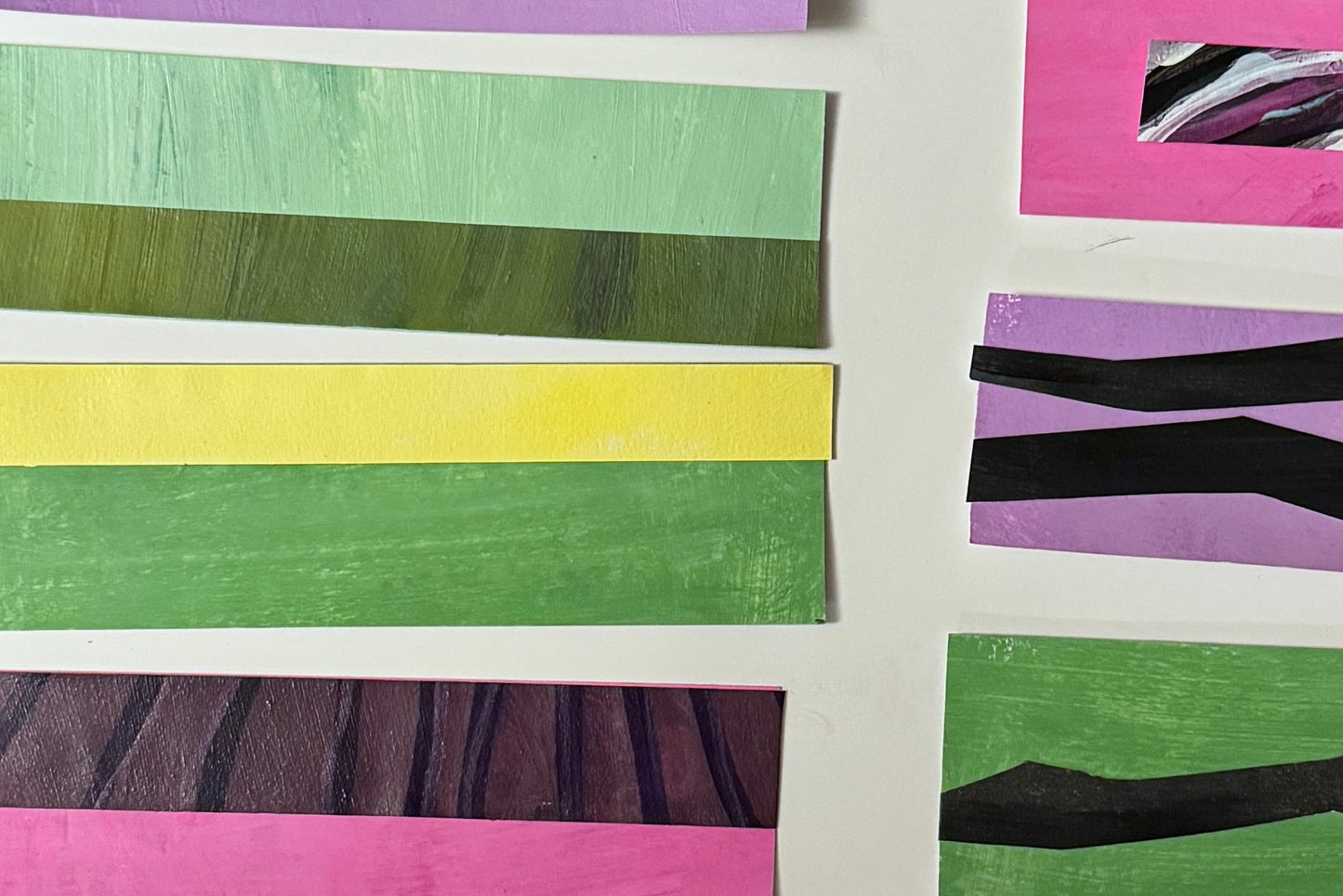 Colorful striped paper strips arranged on a white background.