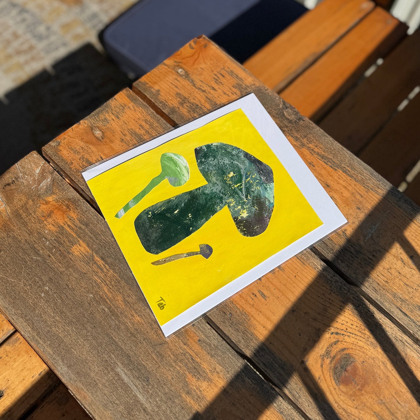 Art with a collage of a mushroom on a wooden surface.