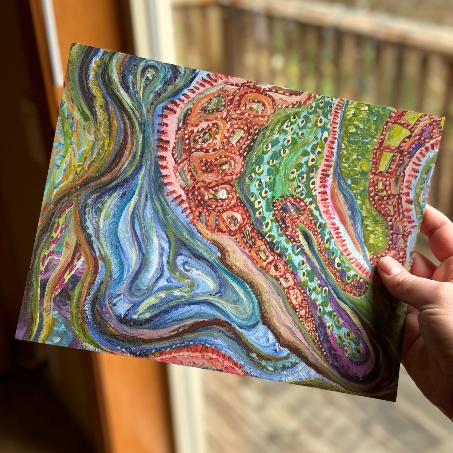 Small, abstract fine art print, Sitting With Thoughts, held by the artist in a cabin window, facing nature.