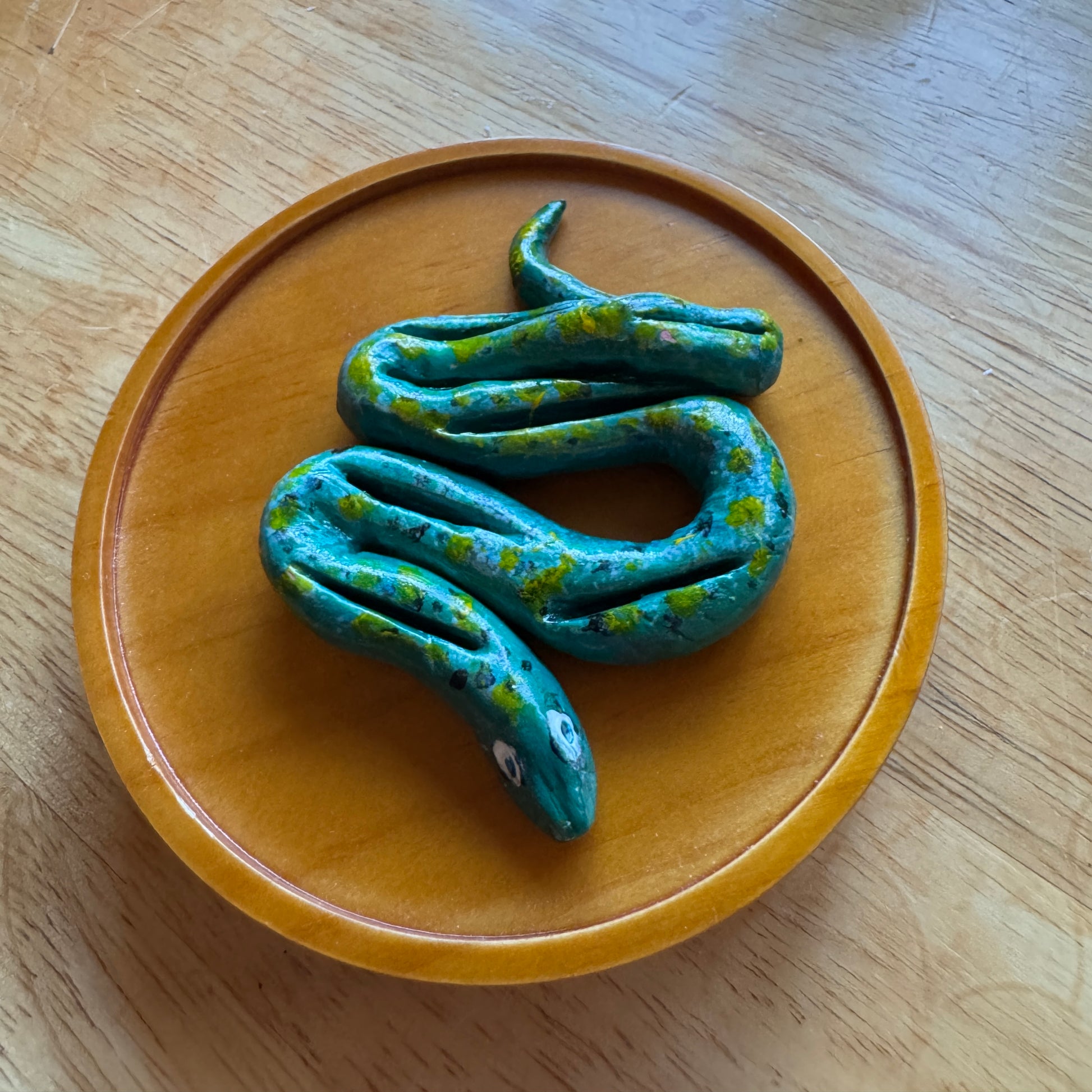 Blue snake-shaped object on a wooden plate