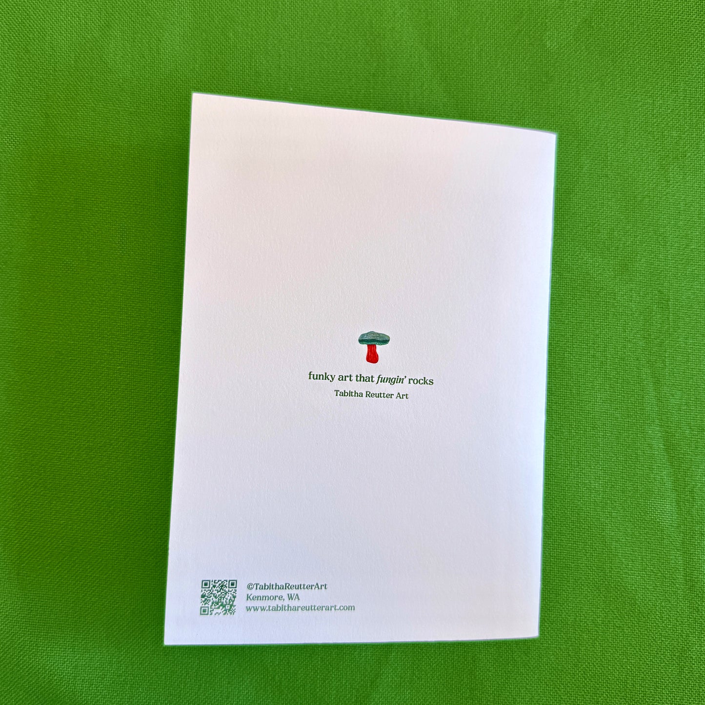 White card with mushroom design and text on a green background
