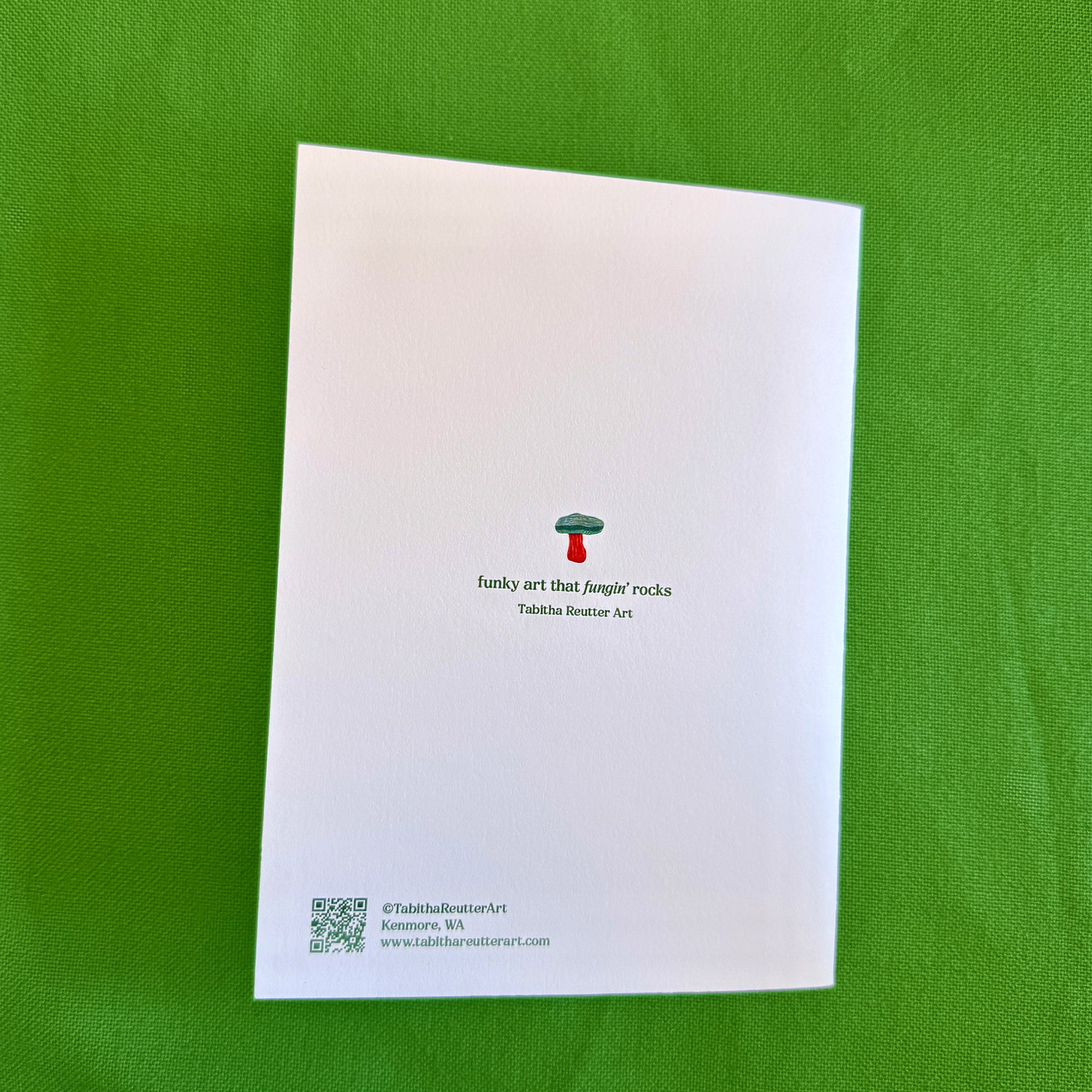 White card with mushroom design and text on a green background