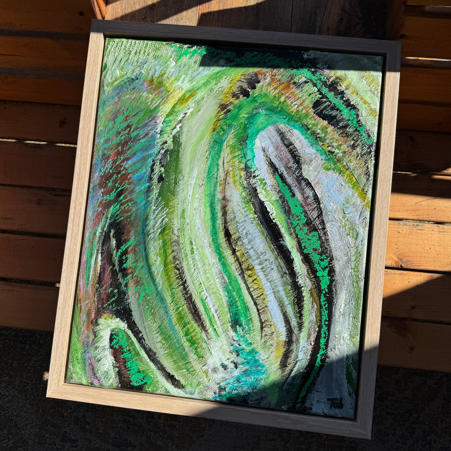 Mixed media, abstract artwork, Somewhere Green, in a beautiful floater frame. Large streaks of green, black, and hints of yellow create a dramatic and vibrant appearance.