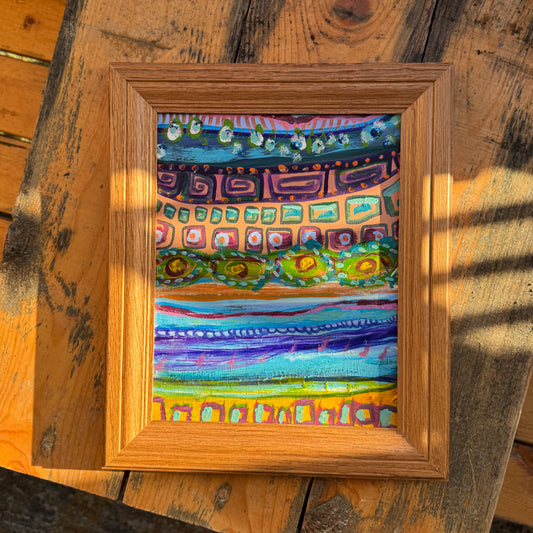 Small abstract, original multimedia artwork, Forward and Backwards, on a sunny day, resting on the top of a wooden table in nature.