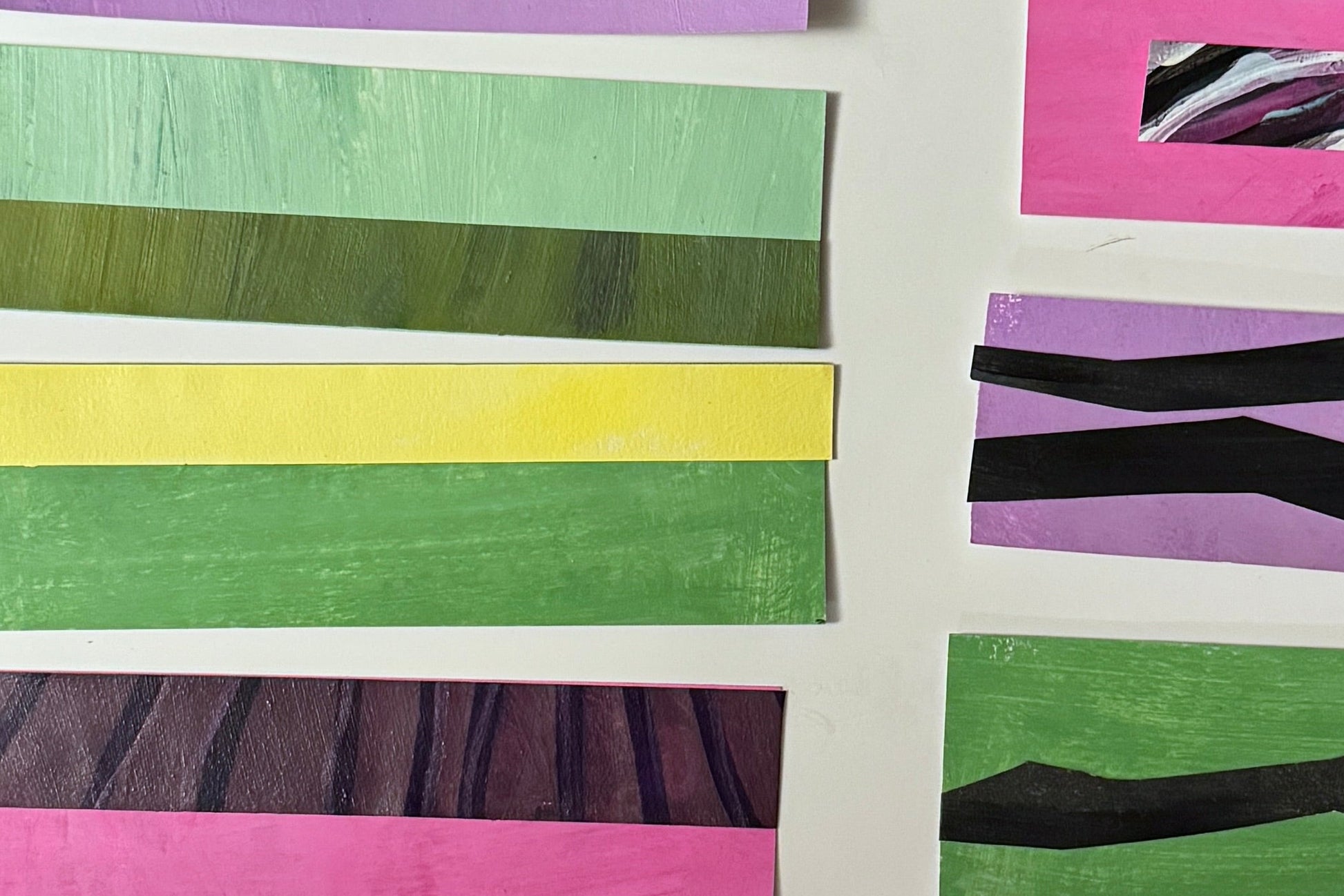 Colorful striped paper strips arranged on a white background.