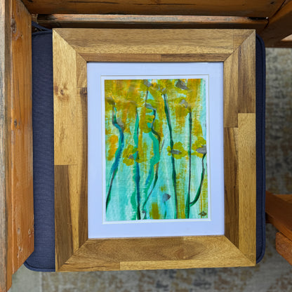 Framed flower artwork with an abstract design on a textured surface.