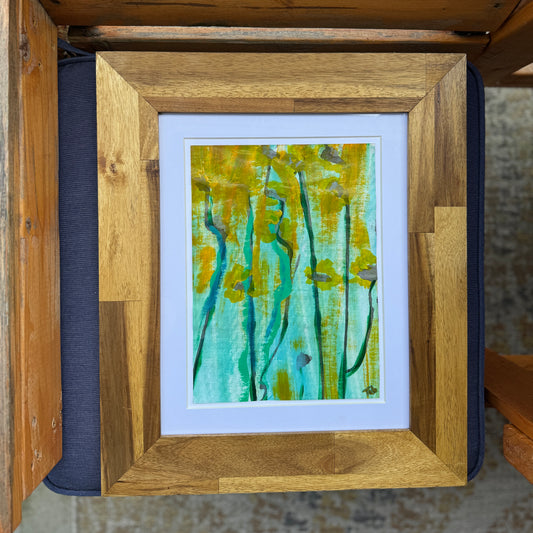 Framed flower artwork with an abstract design on a textured surface.