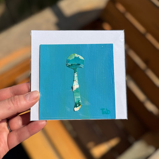 Small collage of a mushroom on a blue background, held in a hand.