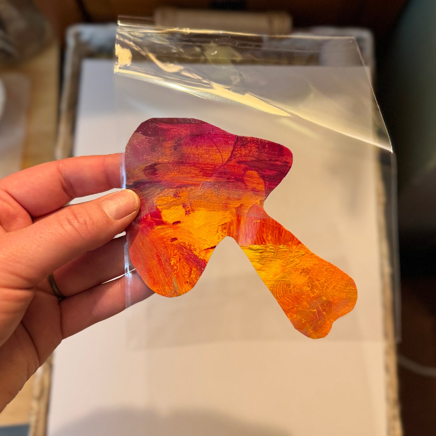 Large handmade mushroom art sticker. The sticker is fiery orange and red, large cap and a strong stem. The sticker is cut organically, with wavy edges, made from leftover paint pallets.