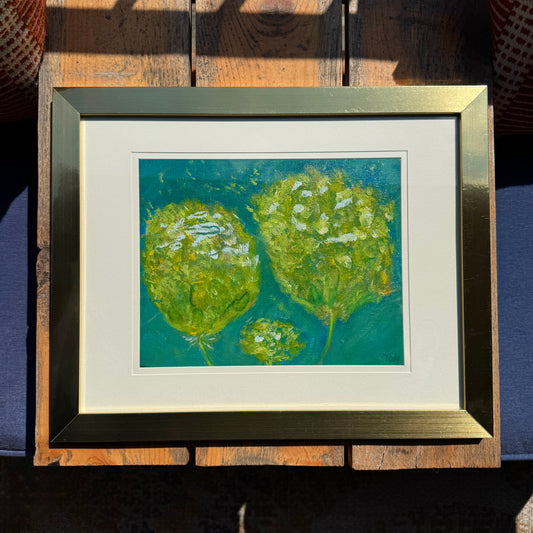 Framed artwork of three abstract green puffy flowers on a blue background.